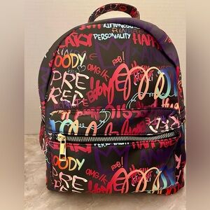 Multi graffiti backpack. Faux vegan leather. Gold tone hardware. Zip top closure